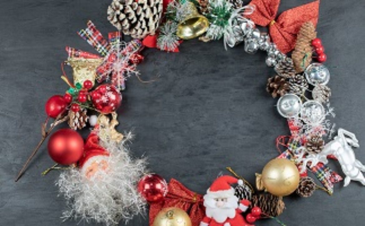 Christmas wreath with festive ornaments on dark background